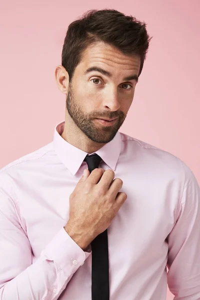 Чувак у рожевій сорочці налаштовує краватку — стокове фото