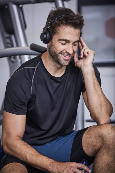 Sonriente en el gimnasio con auriculares — Foto de Stock