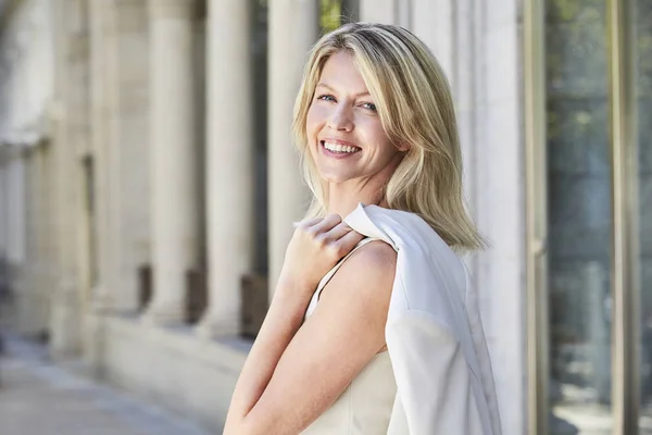 Mooie vrouw in jurk bedrijf jas — Stockfoto