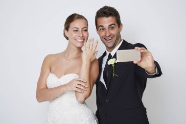 Bride and groom taking selfie on smartphone clipart