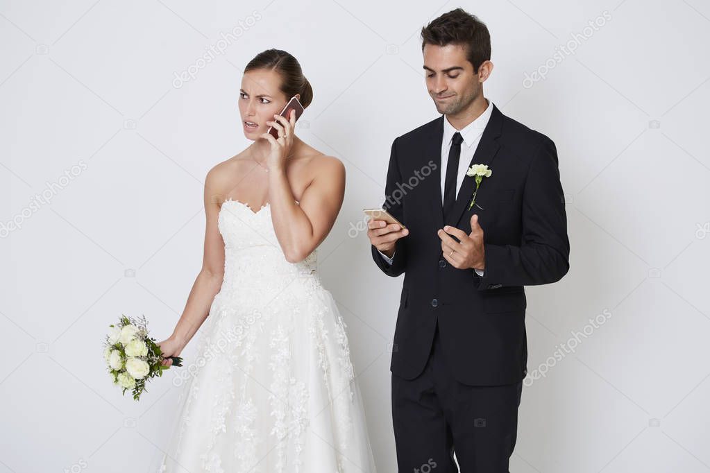 Wedding couple using smartphones
