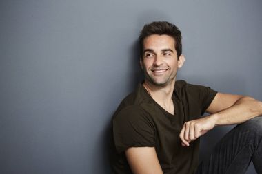 Duvar dibinde oturan rahat adam 