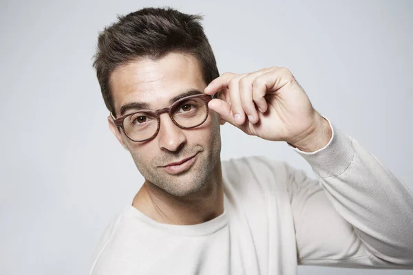 Hombre guapo ajustando gafas — Foto de Stock