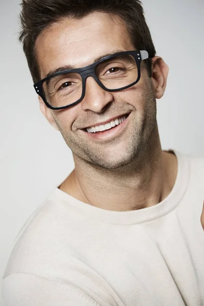 Gözlüklü yakışıklı adam gülümsüyor — Stok fotoğraf