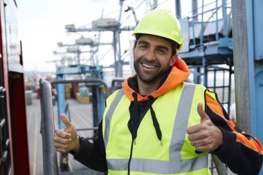 Çift başparmak gösterilen rıhtım işçisi