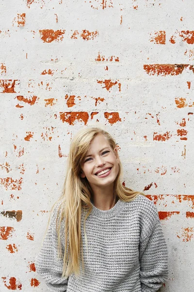 Grinsende blonde Frau im grauen Pullover — Stockfoto