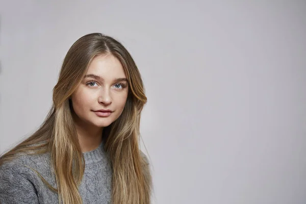 灰色のセーターで若い金髪女性スタジオ — ストック写真
