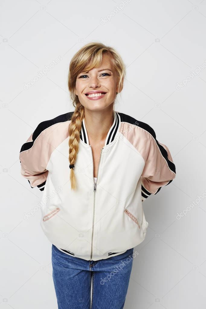 Young woman in jacket posing, smiling to camera
