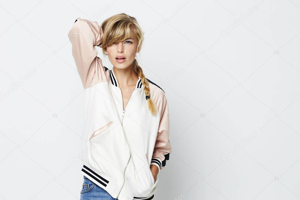 Blond young woman in jacket posing to camera