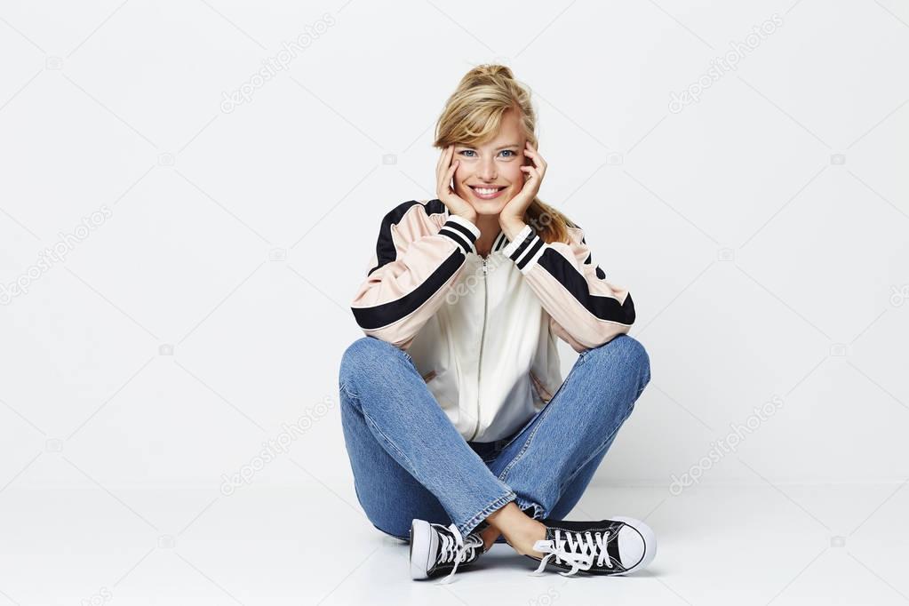 Smiling girl in jacket and jeans, studio shot