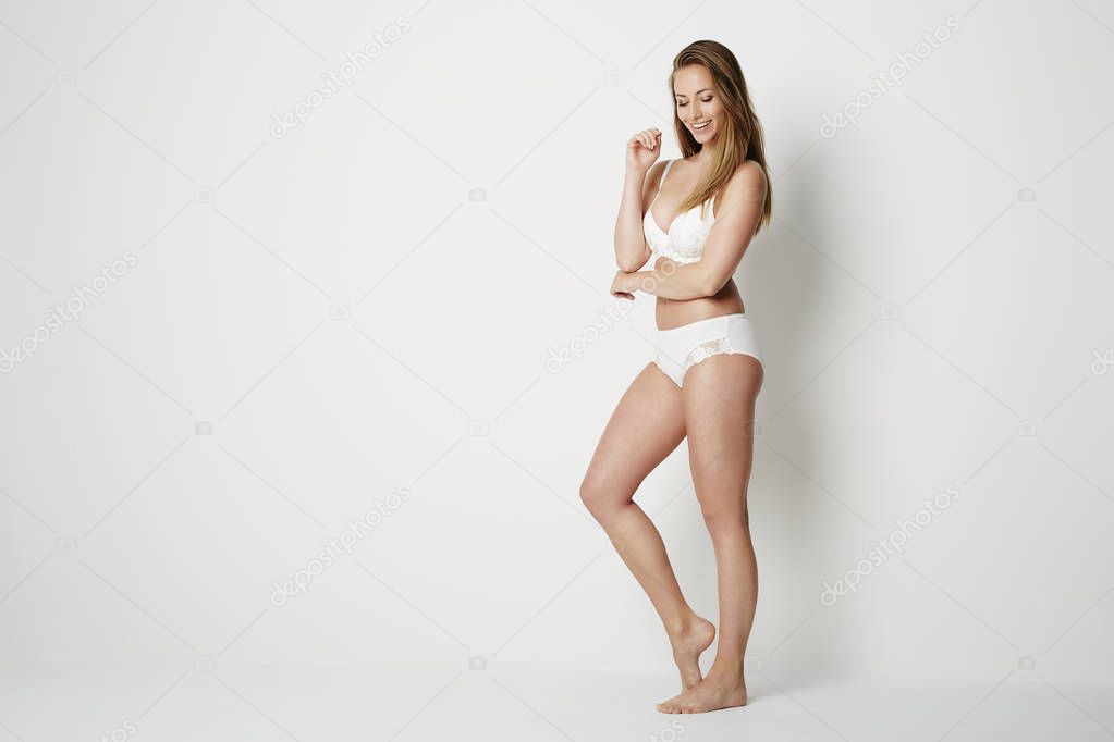 young woman in white lingerie posing looking down