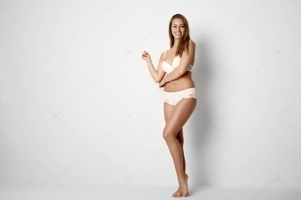 Young woman in white underwear posing at camera