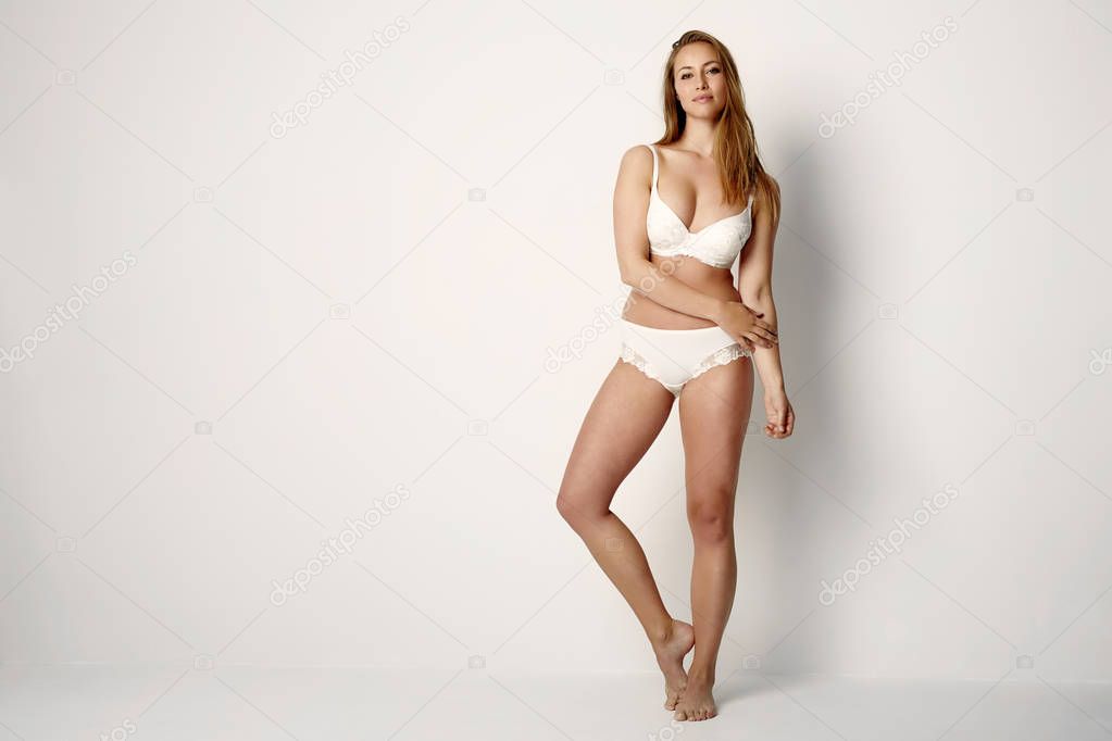 Young woman in white underwear posing at camera