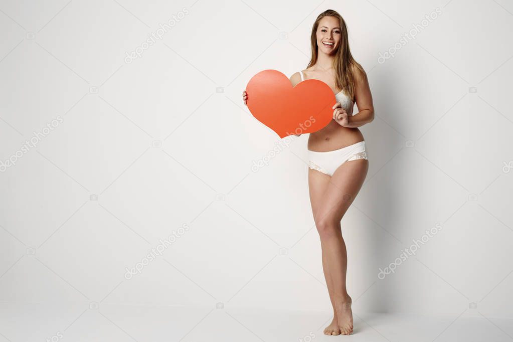 Young woman with a Valentine heart smiling looking at camera