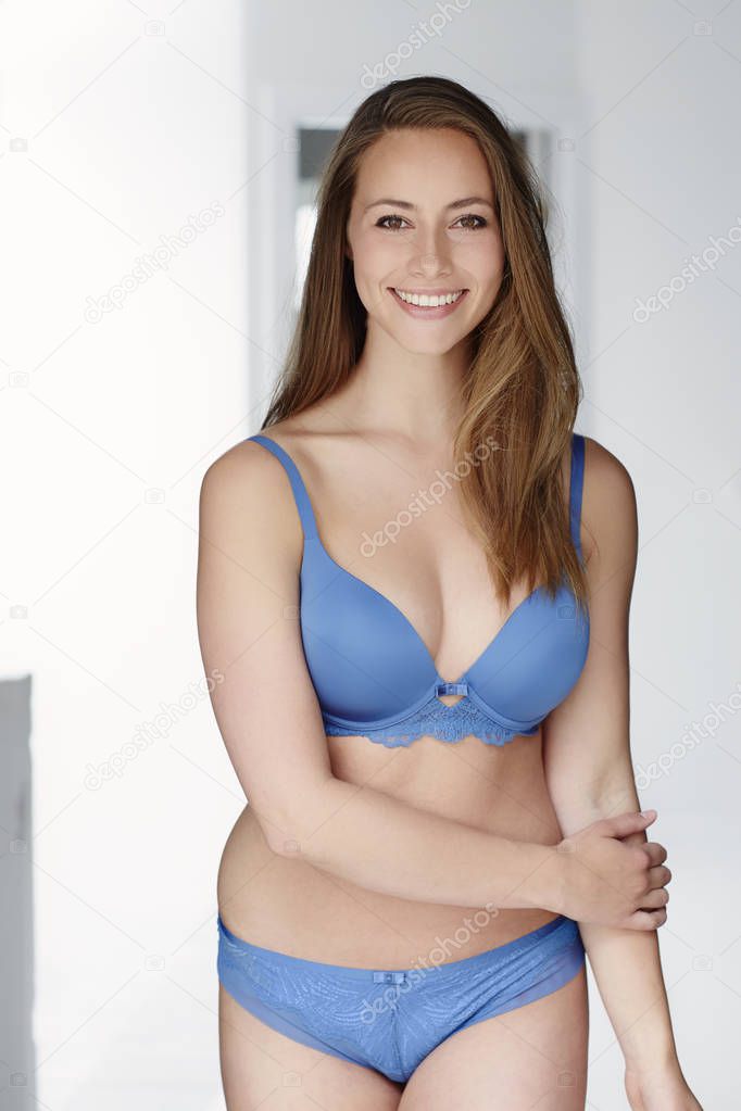 Smiling brunette woman in lingerie posing at camera