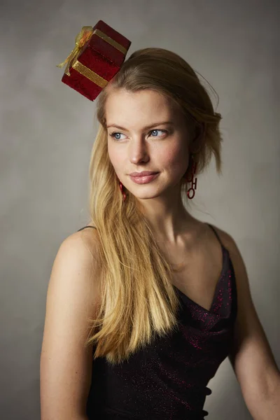 よそ見の頭の上のギフトを持つ若い女性の肖像画 — ストック写真
