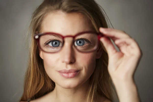 カメラを見てメガネを保持大きな青い目を持つ女性の肖像画 — ストック写真