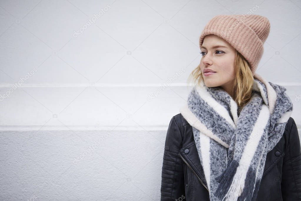 Young woman in hat and scarf looking aside