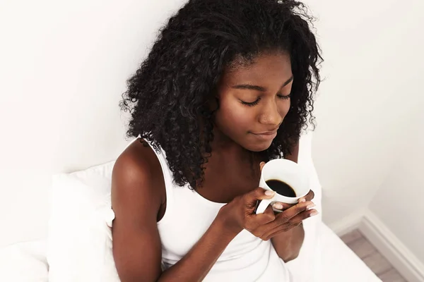 年轻非洲妇女在床上与咖啡杯子 — 图库照片