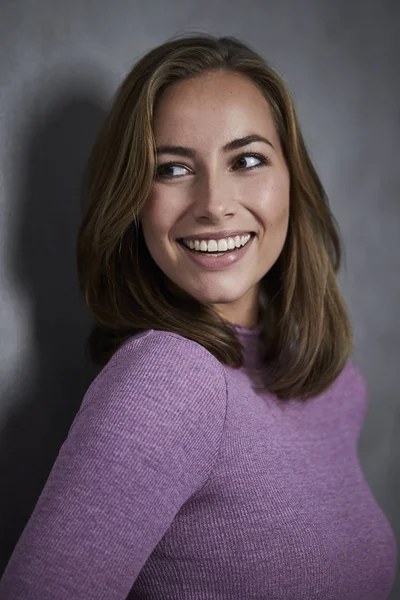 離れて見て笑顔紫のセーター ブルネットの女性の肖像画 — ストック写真