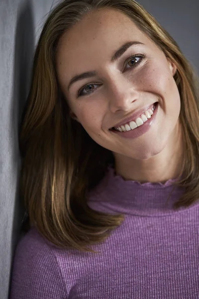 カメラで笑顔の紫のセーターの若いブルネットの女性 — ストック写真