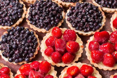 Tartlets ahşap arka plan üzerinde taze yaz meyveleri.
