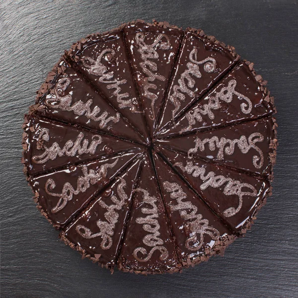 Pastel de chocolate cortado en trozos, sobre fondo negro . — Foto de Stock