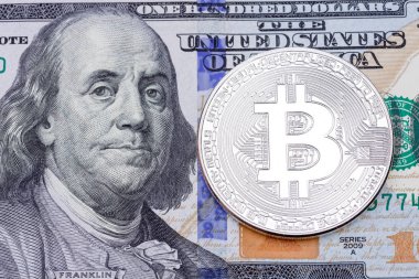 Yüz banknot üzerinde gümüş bitcoin, yakın çekim.