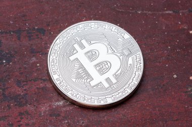 Kırmızı arka plan üzerine gümüş bitcoin ile yakın çekim.