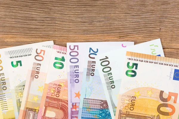 Montón de dinero en euros sobre fondo de madera . — Foto de Stock