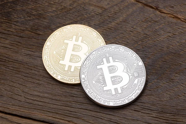 Bitcoins de plata y oro sobre fondo de madera . — Foto de Stock