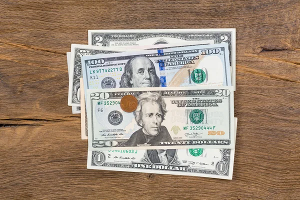 Pocos billetes de dólar con una moneda en la parte superior . — Foto de Stock