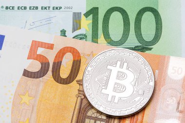 Yüz ve 50 euro arka plan üzerinde gümüş bitcoin. 