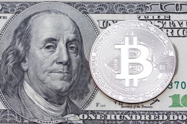 Yüz dolarlık banknot üzerinde gümüş bitcoin.