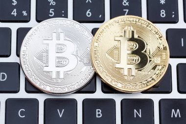 Bitcoin altın ve gümüş sikkeleri üzerinde dizüstü klavye. 