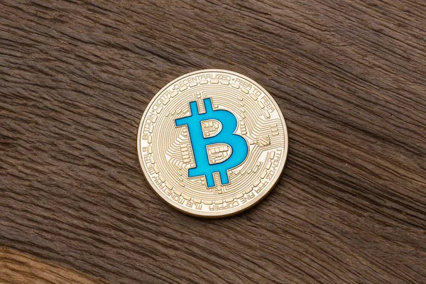 Criptomoneda de oro bitcoin azul sobre fondo de madera, cerca u — Foto de Stock