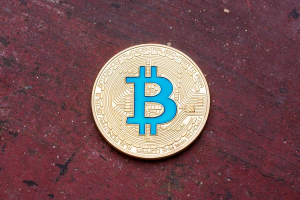 Bitcoin azul criptomoneda de oro sobre fondo rojo, primer plano . — Foto de Stock