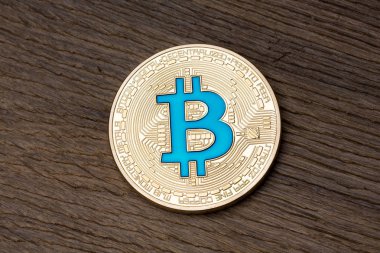 Ahşap zemin üzerine altın mavi bitcoin, yakın çekim.