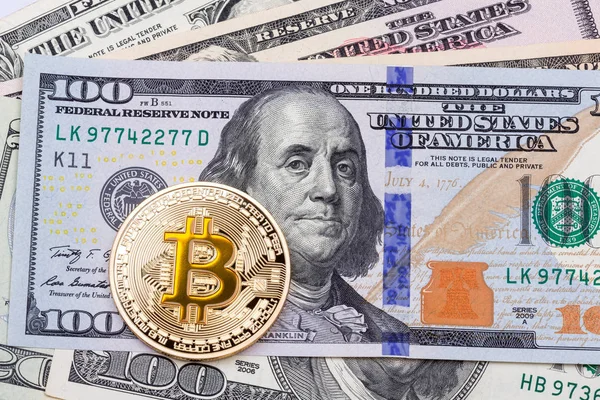 Bitcoin amarillo dorado sobre cien billetes fondo . — Foto de Stock