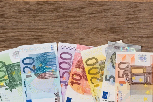 Montón de dinero en euros en escritorio de madera . — Foto de Stock
