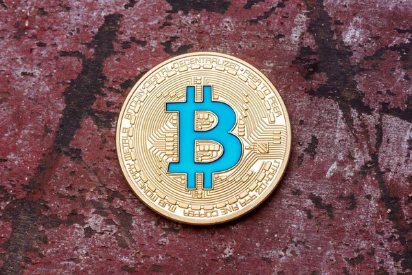 Primer plano de oro criptomoneda bitcoin azul sobre fondo rojo — Foto de Stock