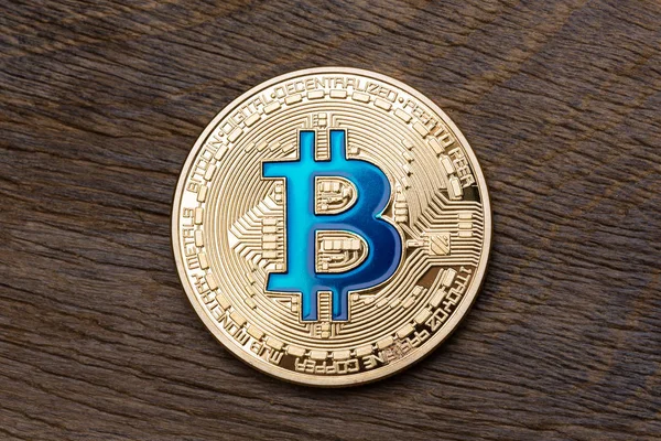 Bitcoin azul criptomoneda de oro sobre fondo de madera . — Foto de Stock