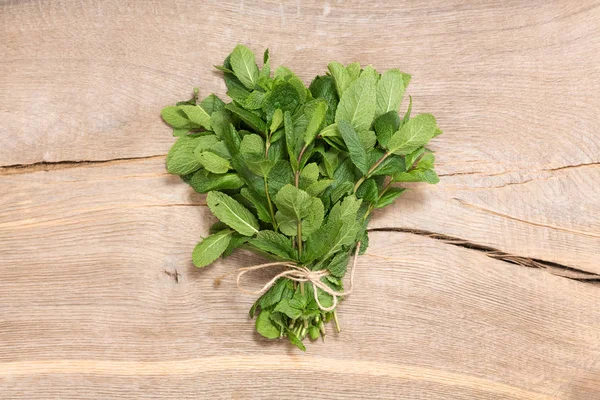 Orijinal ahşap arka plan üzerinde taze nane demet.