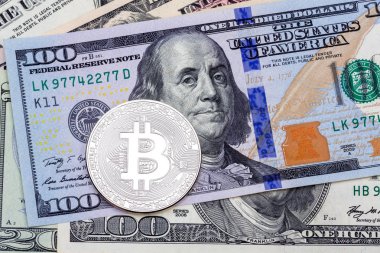 Yüz banknot arka plan üzerinde gümüş bitcoin.