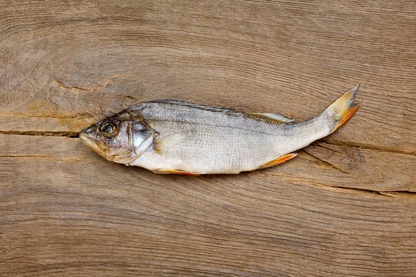 Pesce essiccato sul tavolo. Pesce di fiume secco salato su uno sfondo impressionante di legno . — Foto Stock