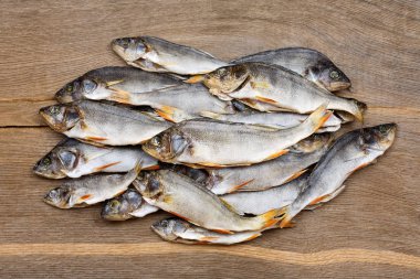 Pek çok kurumuş levrek, eski bir ahşap masa üzerinde yakın plan çekimde..