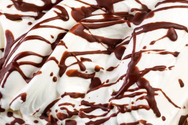 Mass of ice-cream with chocolate syrup. Food background.