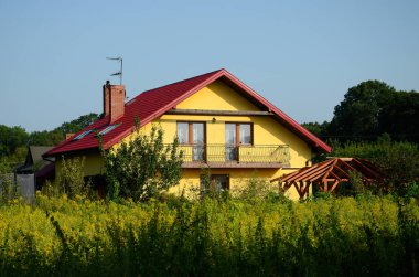 Mavi bir gökyüzü ve yeşil çalılar ile yeni bir kırsal ev