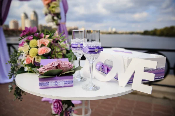 Las copas con el encaje y la caja para los anillos a la mesa a la ceremonia de boda —  Fotos de Stock