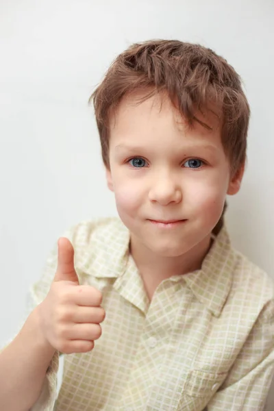 boy gülümseyerek parmağını kaldırdı ve Tamam beyaz bir arka plan üzerinde diyor